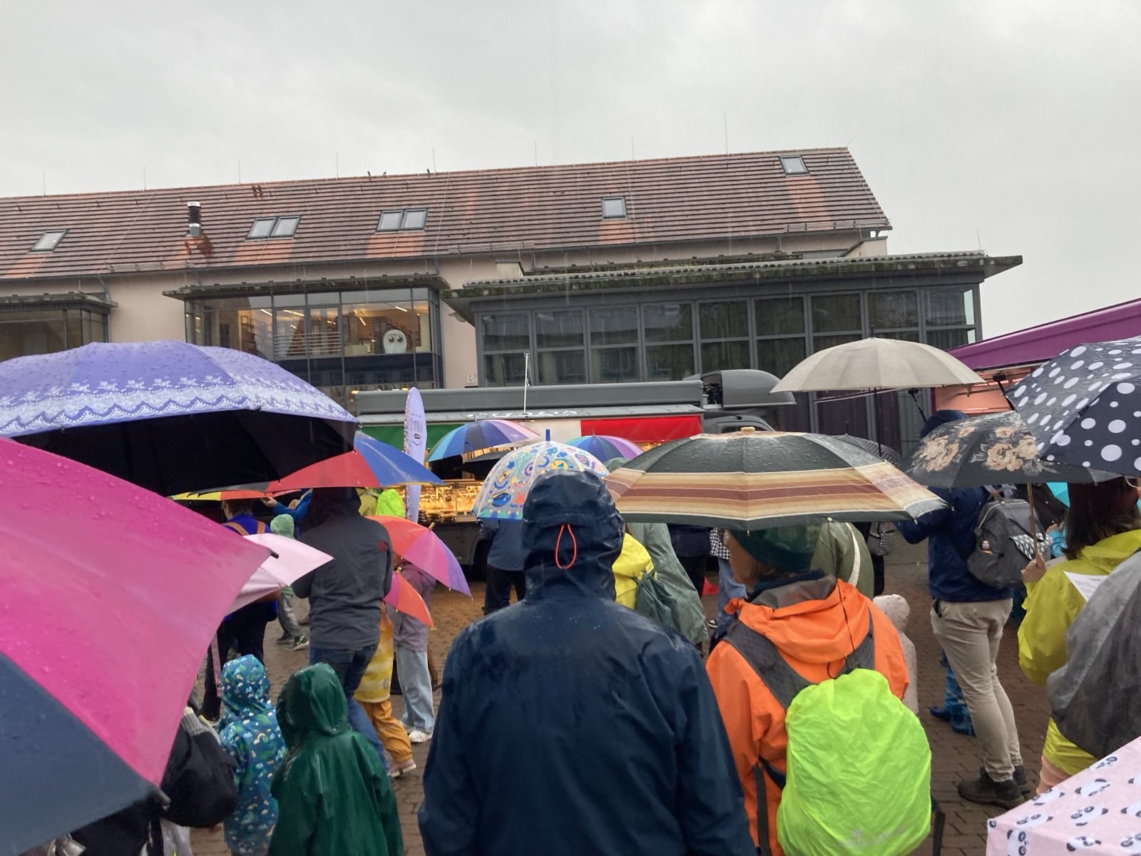 Menschen mit Regenschirmen vor der Kahler Bibliothek